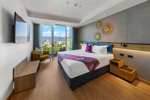 ein Hotelzimmer mit einem Bett und einem Stuhl in der Unterkunft Crystalbrook Flynn in Cairns