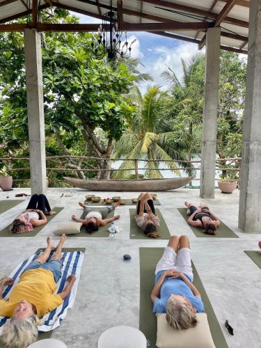 a group of people laying on chaises on the beach at LAKE LOFT - La maison VEDA in Koggala