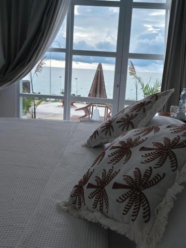 a bed with two pillows with a view of the ocean at Viera Resort in Ngurblut