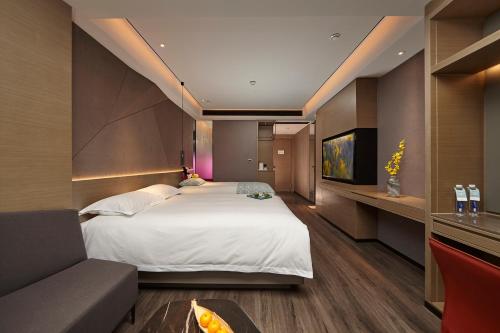 a hotel room with a large bed and a couch at Mercure Tai'an Centre in Tai'an