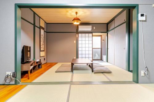 a living room with a table in the middle of a room at Akari Japanese Super Local Tatami House in Kyoto
