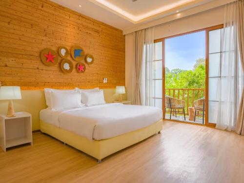 a bedroom with a large bed and a balcony at Thundi by Biosphere in Maalhos