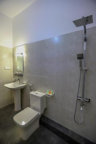 a bathroom with a toilet and a sink and a shower at Negombo Lagoon Hideaway in Negombo