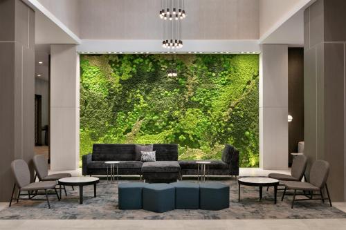 a living room with a couch and a green wall at Embassy Suites by Hilton Atlanta Midtown in Atlanta