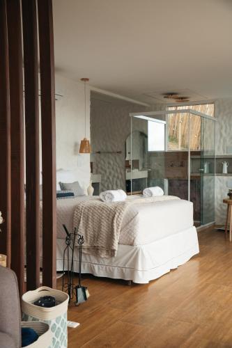 a bedroom with a white bed and a mirror at Cabana Greece house blue in Paty do Alferes