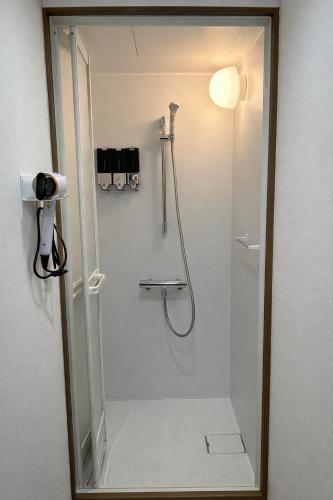 a shower in a bathroom with a mirror at KAMIKURA stay in Shingū