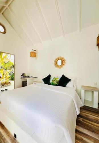 a white bedroom with a large white bed at 101 Sosi in Kudafari