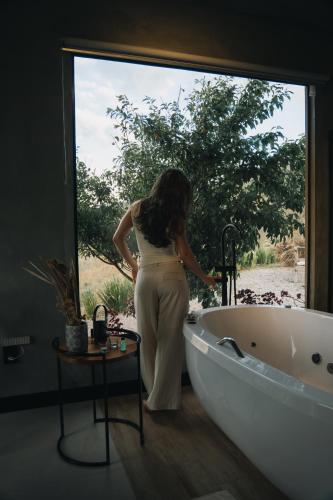 a woman standing next to a tub in a bathroom at Windows House in Paty do Alferes