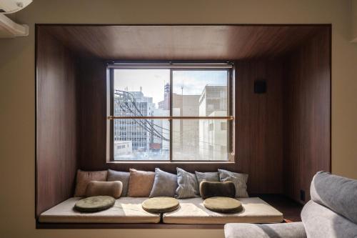 a couch sitting in front of a large window at A&m花畑401 in Kumamoto