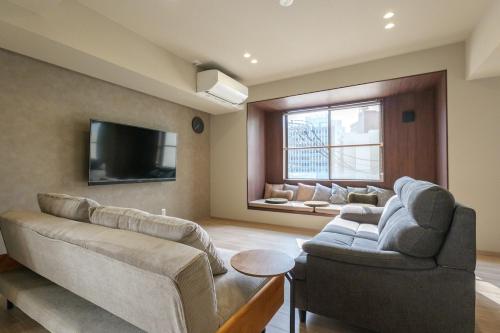 a living room with a couch and a tv at A&m花畑401 in Kumamoto