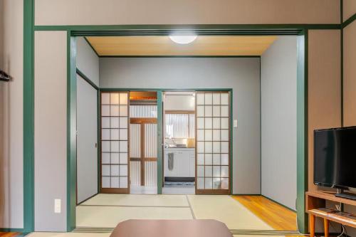 a room with a door leading to a kitchen at Akari Japanese Super Local Tatami House in Kyoto