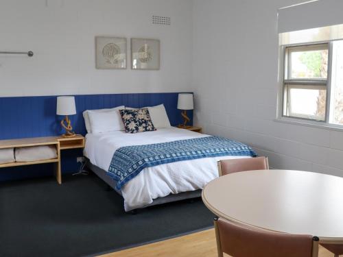 a small room with a bed and a table at Modra's Apartments in Tumby Bay