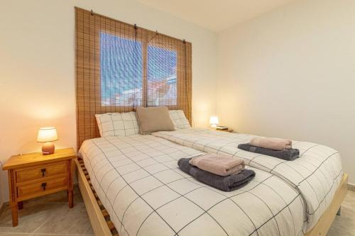 a bedroom with a bed with two pillows and a window at El Nido Apartment in Acantilado de los Gigantes