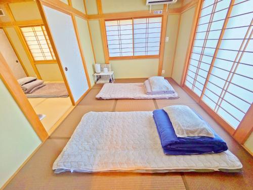 two beds in a room with two windows at パーティーができるビーチハウス海まで1分一棟貸切Qiao105屋外犬可 in Hokota