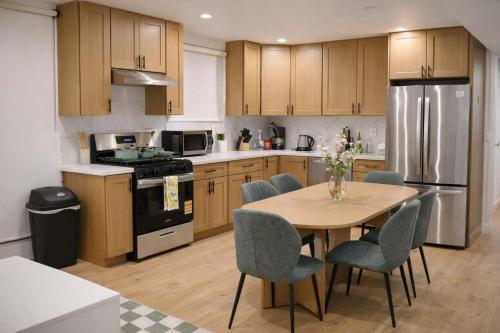 a kitchen with a table and chairs and a refrigerator at Calm Luxe Ensuite Room near USC-Shared Home in Los Angeles