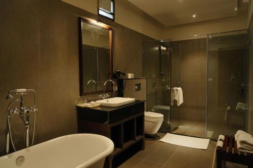a bathroom with a tub and a sink and a toilet at Ranthambhore Aangan in Khilchipur