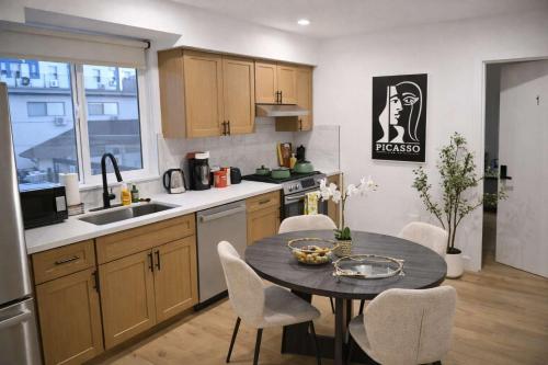 a kitchen with a table and chairs in a kitchen at Luxe Ensuite in Shared Home-Minutes to USC in Los Angeles