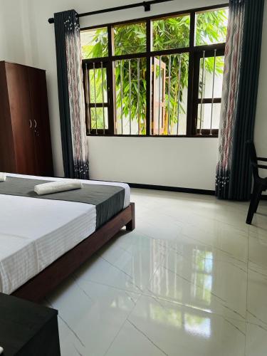 a bedroom with a bed and a large window at Dasis villa in Hiriketiya
