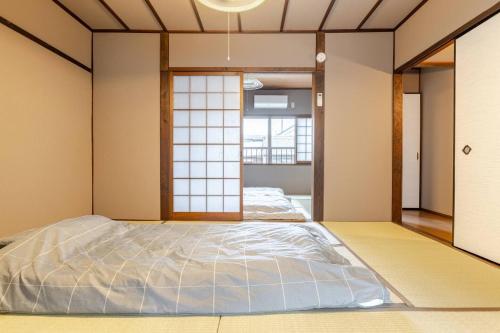 a large bed in a room with a window at Akari Japanese Super Local Tatami House in Kyoto