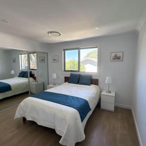 a bedroom with two beds and two windows at House in Burwood 2134 in Sydney