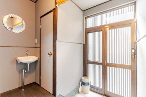 a bathroom with a sink and a mirror and a door at Akari Japanese Super Local Tatami House in Kyoto