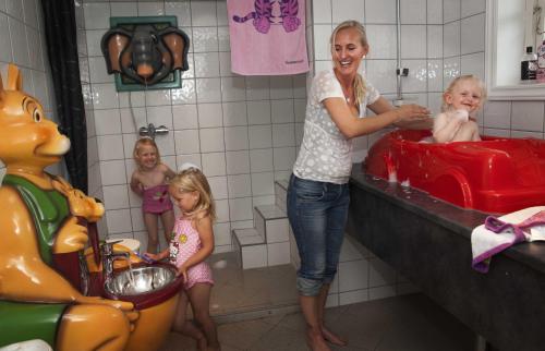 a woman in a bathroom with two children in a sink at Sølvgarden Camping in Rysstad