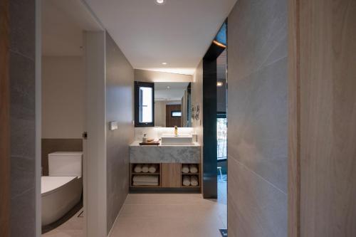 a bathroom with a sink and a bath tub at 롯지호텔 디여라 in Andong