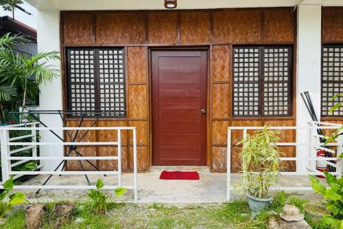 a house with a wooden door and a red rug at Camp Saint John Hotel La Union in San Juan