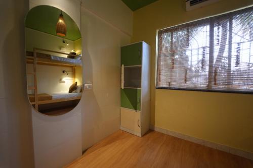 a room with a mirror and a bed and a window at Zen Colive in Pune