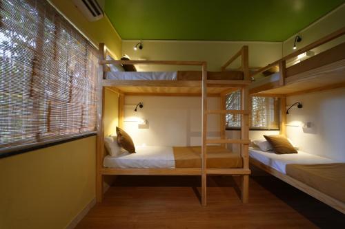 two bunk beds in a room with a green ceiling at Zen Colive in Pune