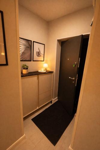 a hallway with a black door and a table at Olympus City Escape in Bucharest