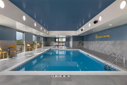 a pool in a hotel room with a swimming pool at Home2 Suites By Hilton Altoona Des Moines in Altoona
