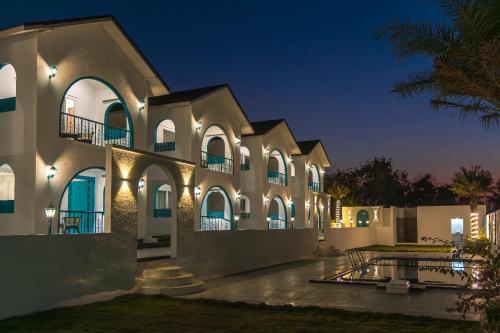 a large building with lights on it at night at Larissa Resort in Nashik