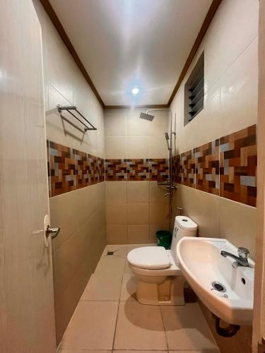 a bathroom with a toilet and a sink at Optimun Inn in Davao City