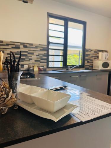 a kitchen with two white bowls on a counter at Heikauiki home in Uturoa