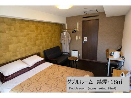 a hotel room with a bed and a chair at Comfort stay Miyabi in Chichibu