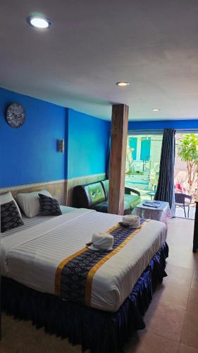 a large bed in a bedroom with a blue wall at Searide hotel in Ao Phutsa