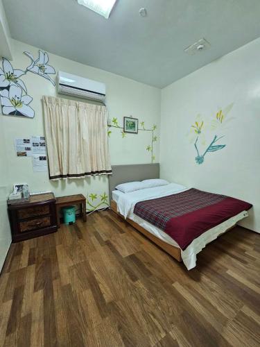 a bedroom with a bed and a wooden floor at 那瑪夏Lu-Mah民宿 in Min-tsu