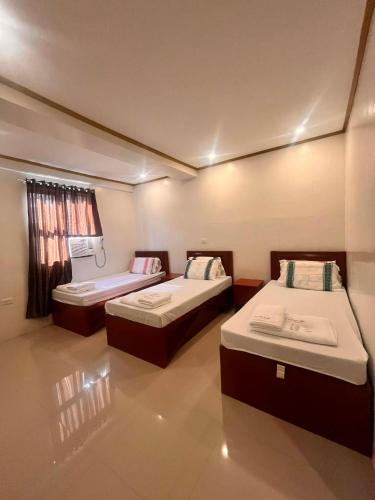 a room with two beds and a window at Optimun Inn in Davao City