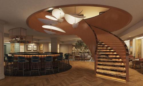 a lobby with a spiral staircase and a bar at Tivoli Coimbra Hotel in Coimbra