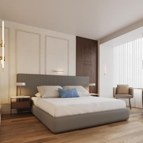 a bedroom with a large white bed and a chair at Tivoli Coimbra Hotel in Coimbra