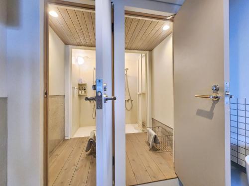a bathroom with a walk in shower and a toilet at ゲストハウス＆カフェ　ハレテル in Masuda