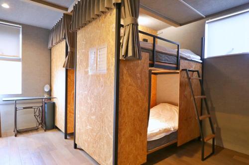 a room with two bunk beds in it at ゲストハウス＆カフェ　ハレテル in Masuda