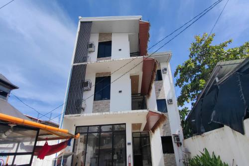 a tall white building with windows at Eva's Guest House in General Luna