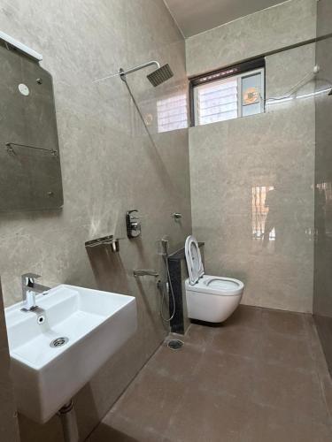 a bathroom with a sink and a toilet at Kailash Residency in Hospet