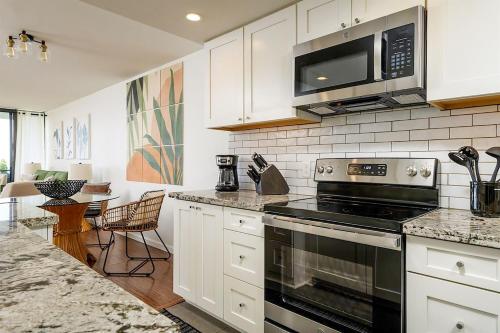 a kitchen with a stove and a microwave at Lauloa 106 in Wailuku