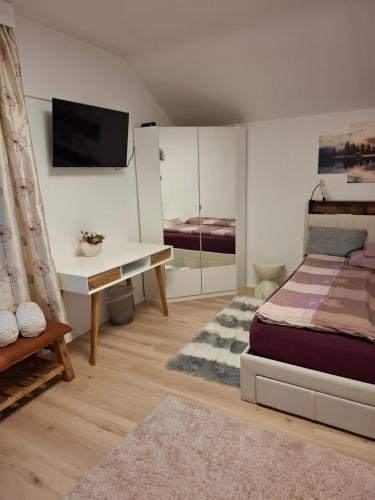 a bedroom with a bed and a desk and a tv at Sterisches Daham in Aflenz Kurort