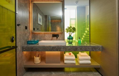 a bathroom with a sink and a mirror at Mercure Tai'an Centre in Tai'an