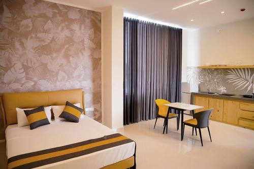 a bedroom with a bed and a table and chairs at Lotus Luxury Residencies in Negombo
