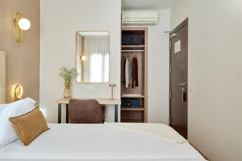 ein Schlafzimmer mit einem Bett, einem Schreibtisch und einem Spiegel in der Unterkunft Hostal Centric in Barcelona